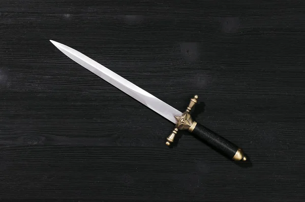 Siyah ahşap arka plan üzerinde izole hançer bıçak.