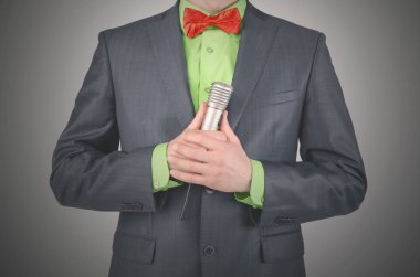 Sunucu radyo mikrofon ile bir konuşma gri bir arka plan üzerinde konuşuyor.