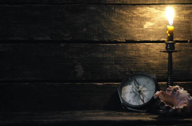 Pusula, deniz kıyısı ve ahşap masa arka plan kopya alanı ile yanan mum. Deniz seyahat veya kavramı macera.