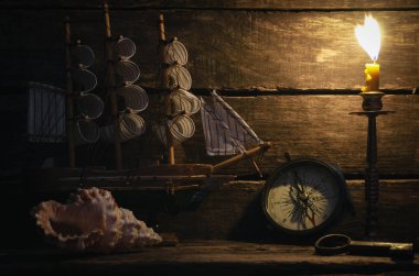 Deniz gemi, pusula, deniz kıyısı ve yanan mum Kaptan masada. Deniz seyahat arka plan. Korsan kavramı.