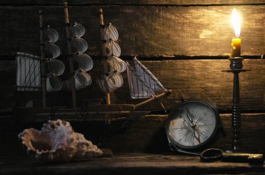 Deniz gemi, pusula, deniz kıyısı ve yanan mum Kaptan masada. Deniz seyahat arka plan. Korsan kavramı.