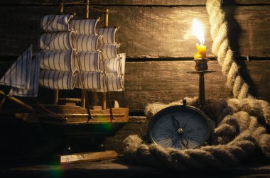 Deniz gemi, halatı, pusula ve Kaptan tablo arka plan üzerinde yanan mum. Deniz seyahat veya arka plan macera.