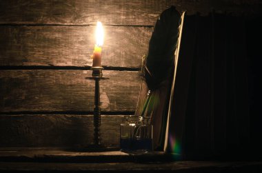 Quill'in kalem inkpot ve yazar Resepsiyon arka plan üzerinde yanan mum ışığında kitap yığını. Eğitim kavramı.