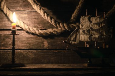 İp demirleme ve ahşap masa mum yanan gemi. Deniz seyahat kavramı arka plan. Korsan.