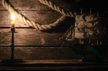 İp demirleme ve ahşap masa mum yanan gemi. Deniz seyahat kavramı arka plan. Korsan.