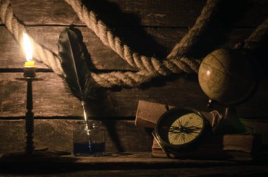 Deniz seyahat arka plan. Arka plan macera. Küre, pusula, demirleme ip, kaydırma harita, tüy kalem inkpot günlüğü kitap ve yanan mum bir ahşap Kaptan tablo.