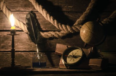 Deniz seyahat arka plan. Arka plan macera. Küre, pusula, demirleme ip, kaydırma harita, tüy kalem inkpot günlüğü kitap ve yanan mum bir ahşap Kaptan tablo.