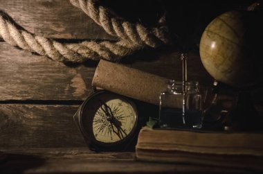 Deniz seyahat arka plan. Arka plan macera. Küre, pusula, demirleme ip, kaydırma harita, tüy kalem inkpot günlüğü kitap ve yanan mum bir ahşap Kaptan tablo.