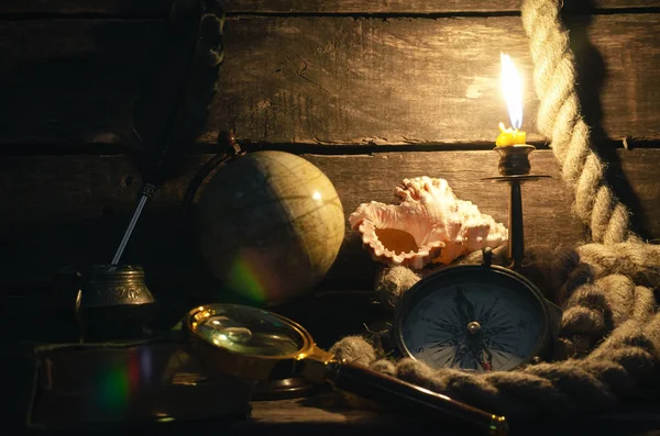 Deniz seyahat arka plan. Arka plan macera. Pusula, küre, Büyüteç, demirleme ip, tüy kalem inkpot, günlüğü kitap ve yanan mum bir ahşap Kaptan tablo.