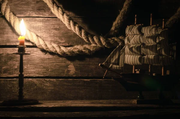 İp demirleme ve ahşap masa mum yanan gemi. Deniz seyahat kavramı arka plan. Korsan.