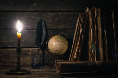 Quill'in kalem inkpot, küre ve yazar Resepsiyon arka plan üzerinde yanan mum ışığında kitap yığını. Eğitim genel kavram ya da seyahat günlüğü.