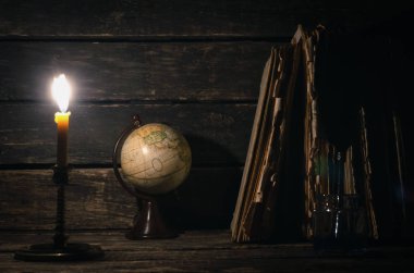 Quill'in kalem inkpot, küre ve yazar Resepsiyon arka plan üzerinde yanan mum ışığında kitap yığını. Eğitim genel kavram ya da seyahat günlüğü.