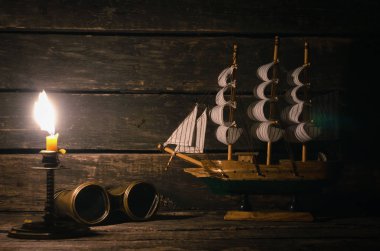 Gemi, dürbün ve ahşap masa üzerinde yanan mum. Deniz seyahat kavramı arka plan. Korsan Kaptan Resepsiyon.