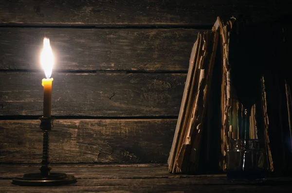 Ganzenveer Een Inkpot Stapel Boeken Het Licht Van Kaars Branden — Stockfoto