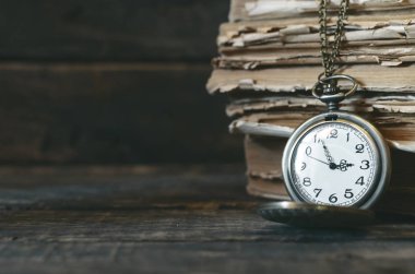 Cep saati ve yazar masasında kitap yığını. Okula dönüş.