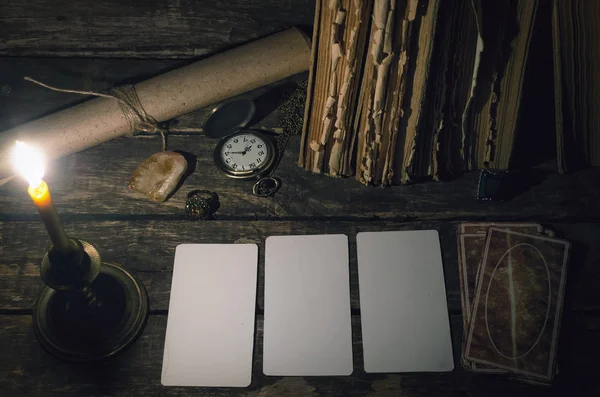 Tarot cards with copy space mockup on fortune teller table in the lights of burning candle background. Futune reading concept. Divination.