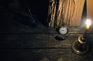 Quill'in kalem InkWell ve yazar Resepsiyon arka plan üzerinde yanan mum ışığında kitap yığını. Eğitim kavramı.