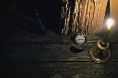 Quill'in kalem InkWell ve yazar Resepsiyon arka plan üzerinde yanan mum ışığında kitap yığını. Eğitim kavramı.