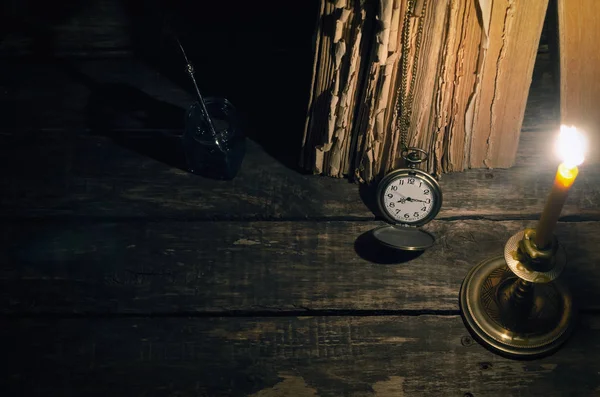 Quill'in kalem InkWell ve yazar Resepsiyon arka plan üzerinde yanan mum ışığında kitap yığını. Eğitim kavramı.