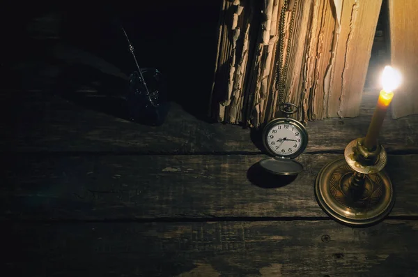 Quill'in kalem InkWell ve yazar Resepsiyon arka plan üzerinde yanan mum ışığında kitap yığını. Eğitim kavramı.