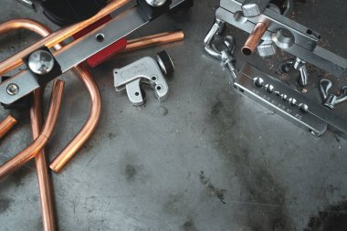 Borular, boru rammer ve boru bender ve kesici aracı kopya alanı bir tesisatçısı tezgah zemin üzerine. Üstten görünüm fotoğraf.