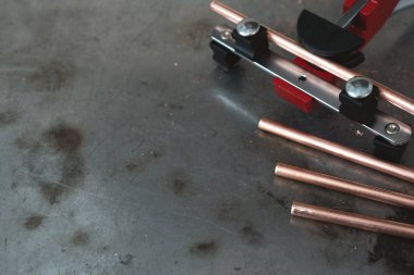 Boru bender aracı ve bir pirinç borular tesisatçısı arka plan kopya alanı ile bir tezgah üzerinde.