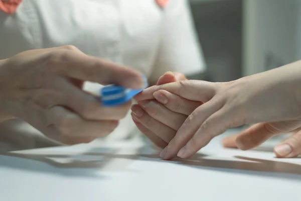 Manicurist polishes fingernails with manicure buff. Nail preparation for nail polish.