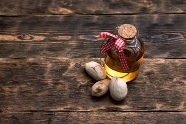 Pekan somun petrol kahverengi ahşap masa arka plan üzerine bir şişe.