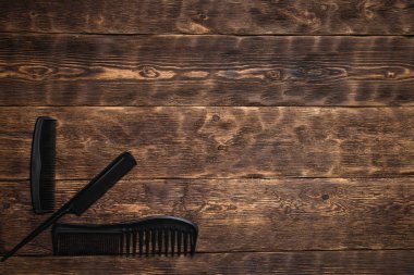 Kuaför iş tablo arka plan kopya alanı ile. Bir ahşap tahta üzerinde çeşitli bir tarak.