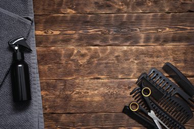 Kuaför iş tablo arka plan kopya alanı ile. Böyle bir fırçaları, püskürtme, havlu ve makas bir ahşap tahta üzerinde çeşitli kuaförlük araçları.