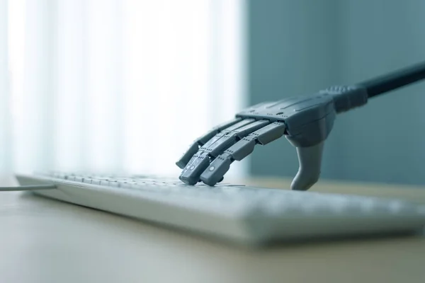 人工知能とロボットは コンピューターに取り組んでいます ロボット アームは コンピューターのキーボードのキーを推進します — ストック写真