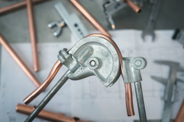 Boru bender aracı fabrika işçisi bir fabrika tezgah arka plan üzerinde elinde. Tesisatçı bir boru bükme. Boru işi.