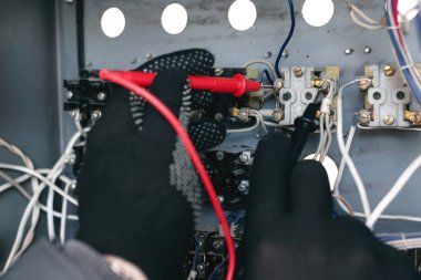 Elektrikçi ile bir multimetre gerilim içinde belgili tanımlık tesisat elektrik devresi kontrol ediyor. Elektrik İnşaat kavramı arka plan.