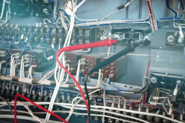Elektrikçi ile bir multimetre gerilim içinde belgili tanımlık tesisat elektrik devresi kontrol ediyor. Elektrik İnşaat kavramı arka plan.