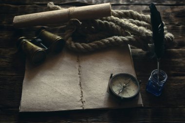 Boş Gezgin defter, Pusula, dürbün, ip ve inkpot bir ahşap masa arka plan mockup üzerinde tüy kalemle demirleme. Maceracı notlar. 