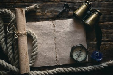 Boş Gezgin defter, Pusula, dürbün, ip ve inkpot bir ahşap masa arka plan mockup üzerinde tüy kalemle demirleme. Maceracı notlar. 