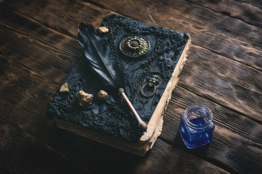 Antik sihirli kitap, mürekkep iyi ve quill kalem bir ahşap masa arka plan üzerinde. Büyü kitabı.