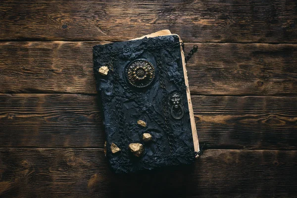 Ahşap bir masa arkasında antik bir büyü kitabı. İmla Defteri.