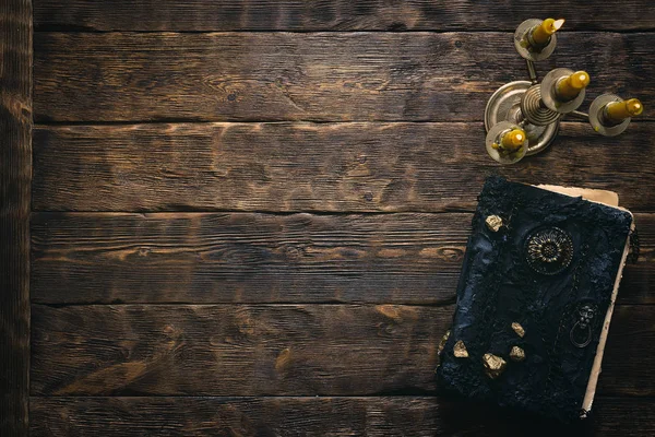 Antik sihirli kitap ve kopya alanı bir ahşap masa zemin üzerine yanan mum. Spellbook.