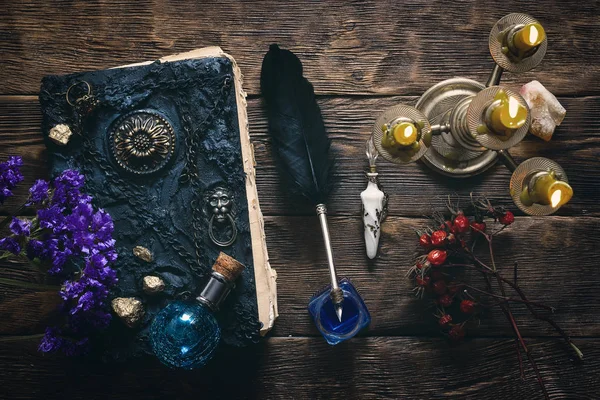 Spell book, magic potions and other various witchcraft accessories on the wizard table background.