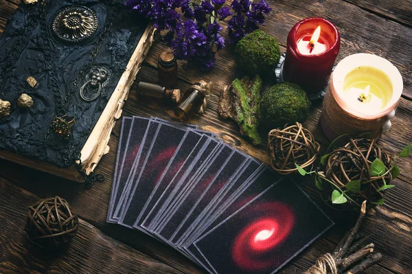 Tarot cards and book of magic on a wooden table background. Future reading.