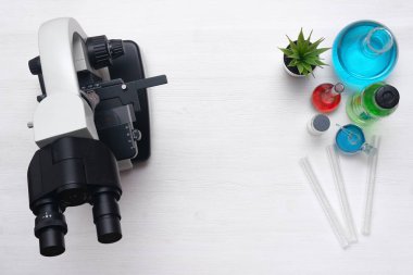 Laboratuvar mikroskop ve kimyasal reaktif sıvı yukarıdaki tablo. Kimya veya eczane arka plan kopya alanı ile. Düz yatıyordu.