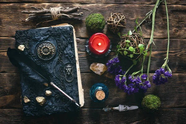 Spell book, magic potion and dryed herbs on the wizard table background.