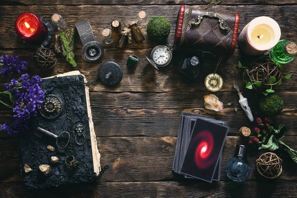 Tarot cards, book of magic and pocket watch on a wooden table background. Future reading.