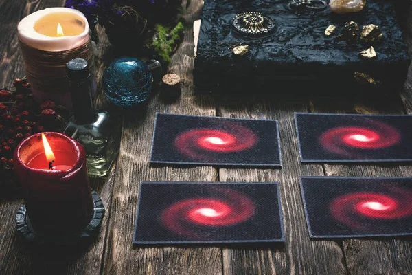 Tarot cards and book of magic on a wooden table background. Future reading.