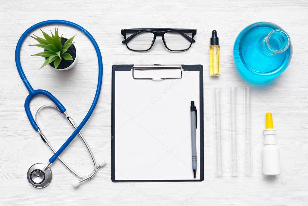 Medical examination list mockup. Laboratory table with a stethoscope, blank paper sheet of researching results and a chemical reagents background with copy space. Flat lay.