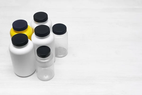 白色木制桌子背景上的运动营养罐 — 图库照片