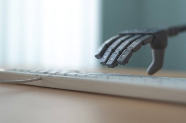 Robot yapay zeka ile bir bilgisayarda çalışıyor. Robotik kol a anahtar taşı üstünde a bilgisayar klavye bastırıyor.