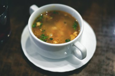 Bir tablo üzerinde beyaz bir kase erişte çorbası.