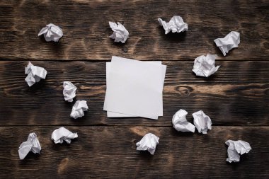 Boş kağıt levha ve buruşuk sayfalarında bir ahşap tahta arka plan etrafında.